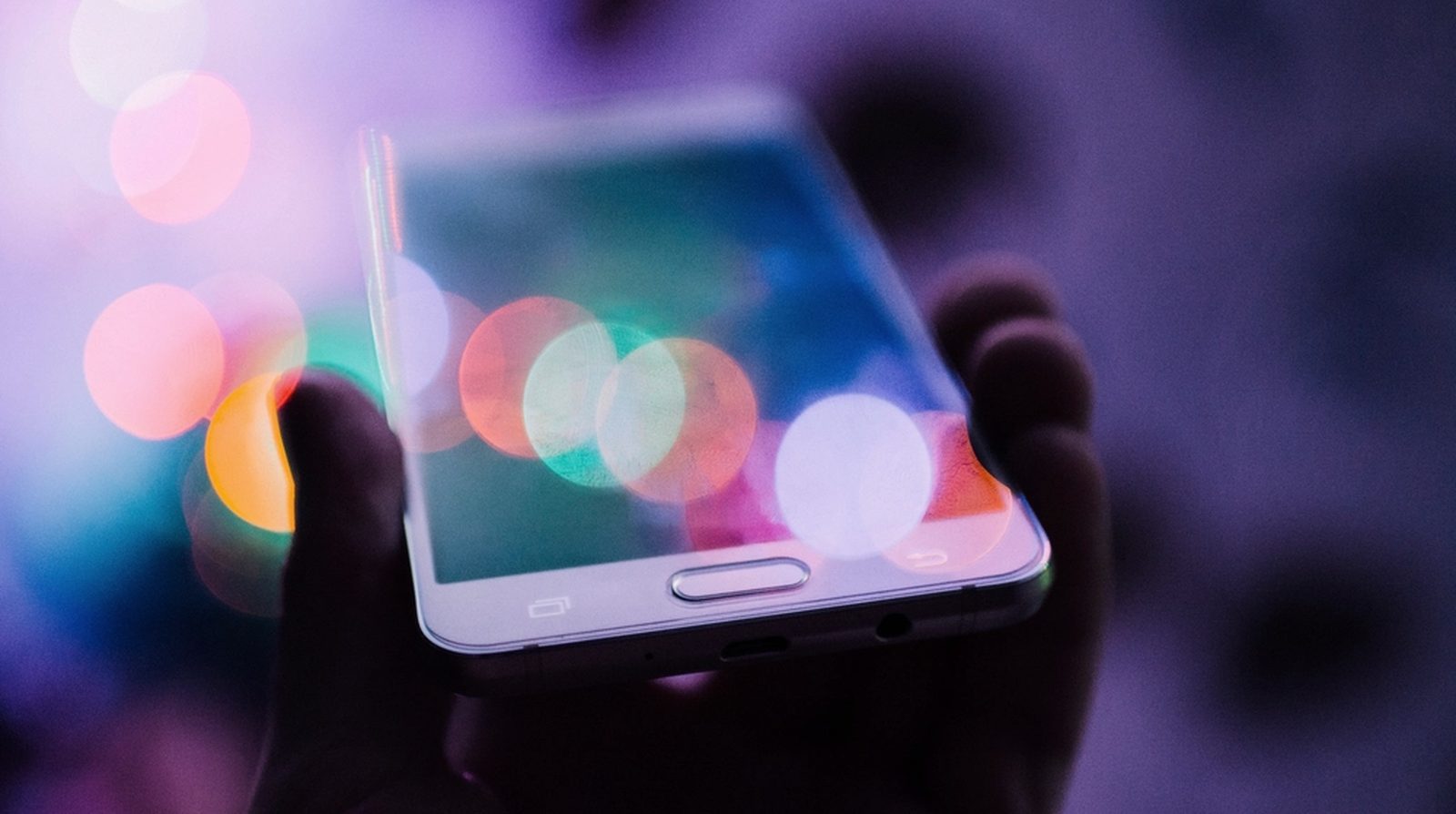 A glowing phone in the palm of a hand