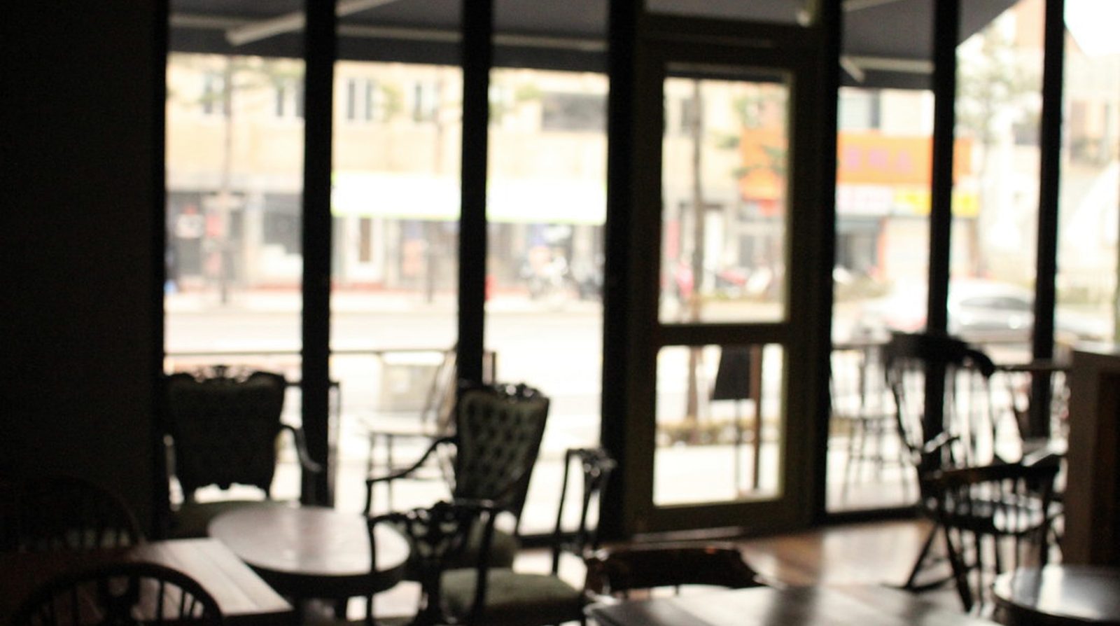Không gian quán cafe nhà hàng cải tạo với kết cấu lộ: dầm bê tông, gác lửng khung thép và hệ khung mái che khu ngồi ngoài trời