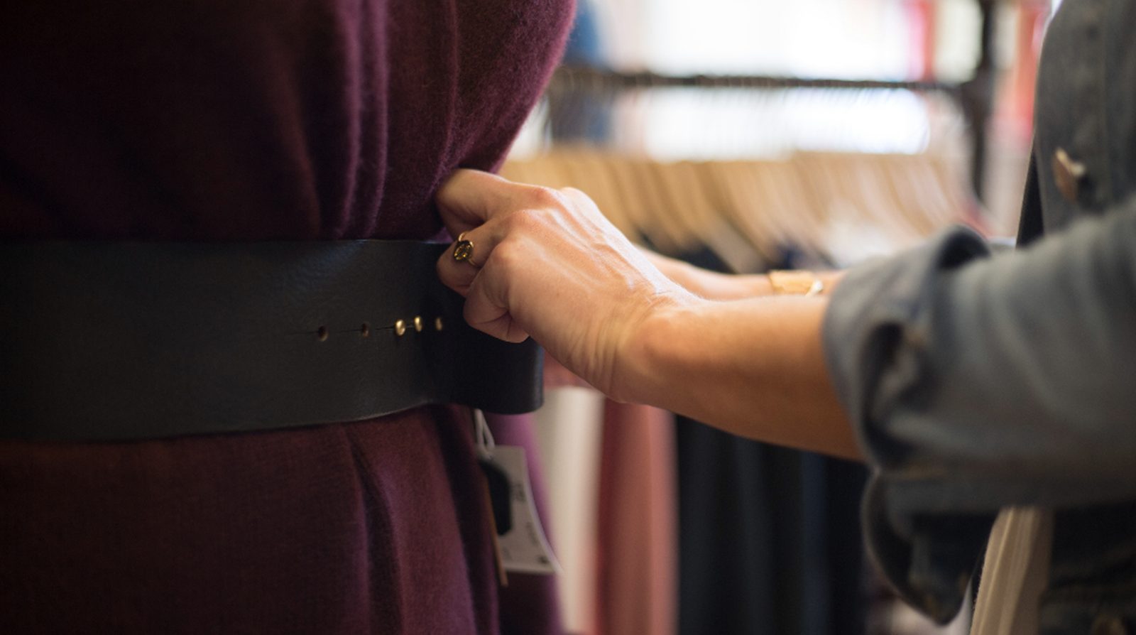 A shopper browsing a clothing rack in a store