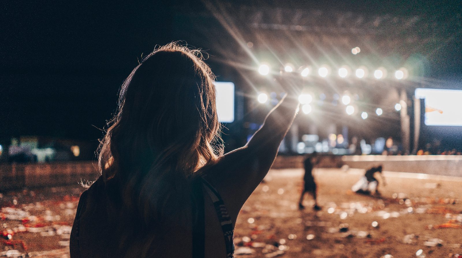 Attendees at a night-time outdoor event facing the stage, the kind of setting that needs one person dedicated to weather watch