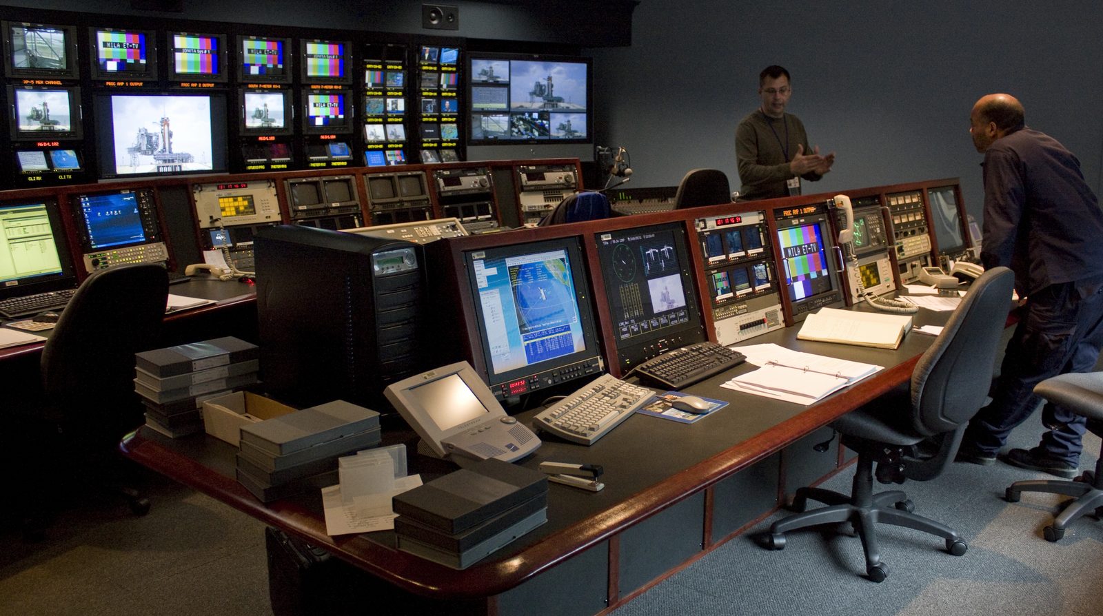 A control room with banks of monitoring screens and engineers on shift, the observe-and-log posture most organisations apply to AI agents