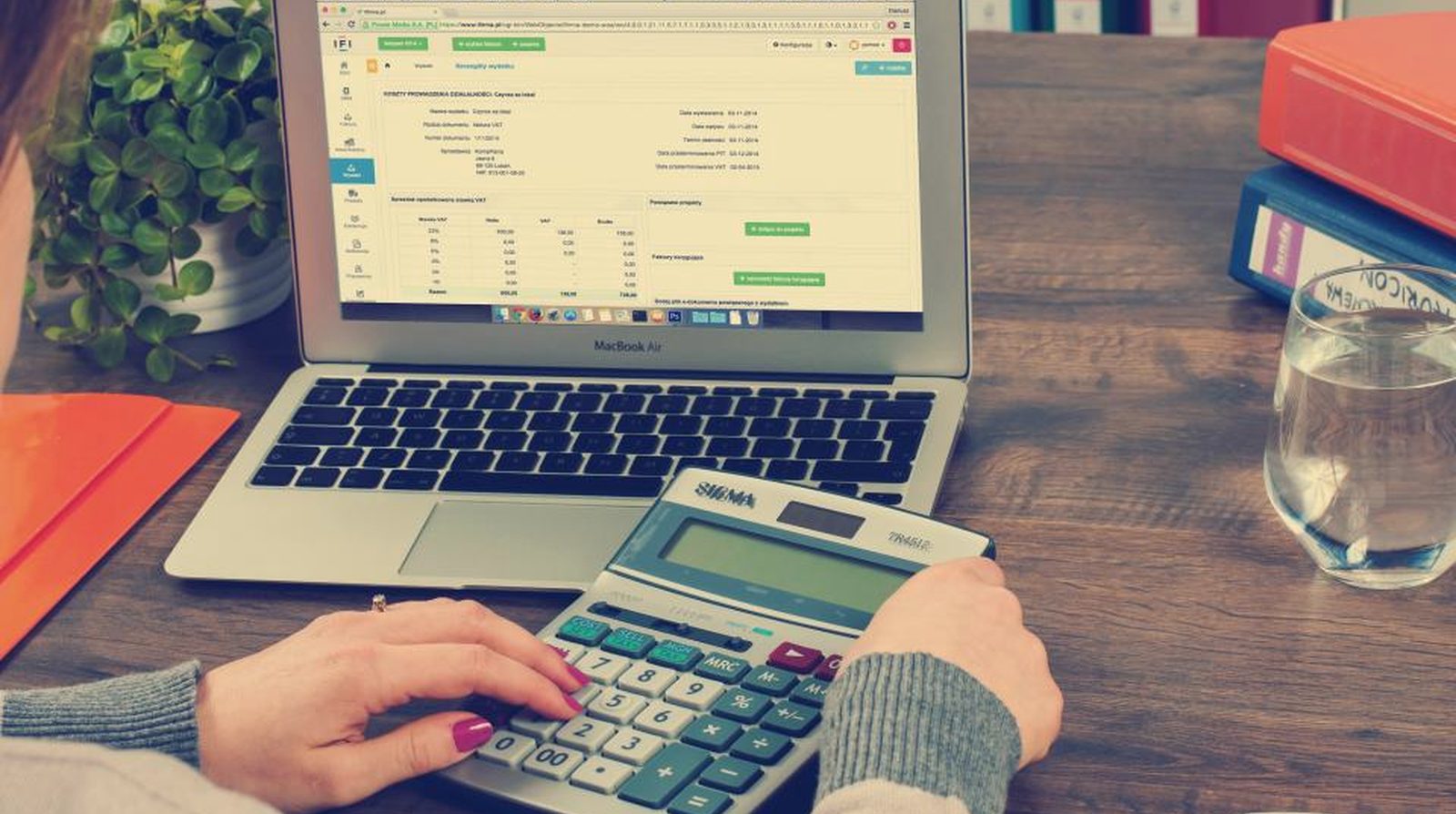 A desk with a laptop showing figures next to a calculator, the work of setting a security budget