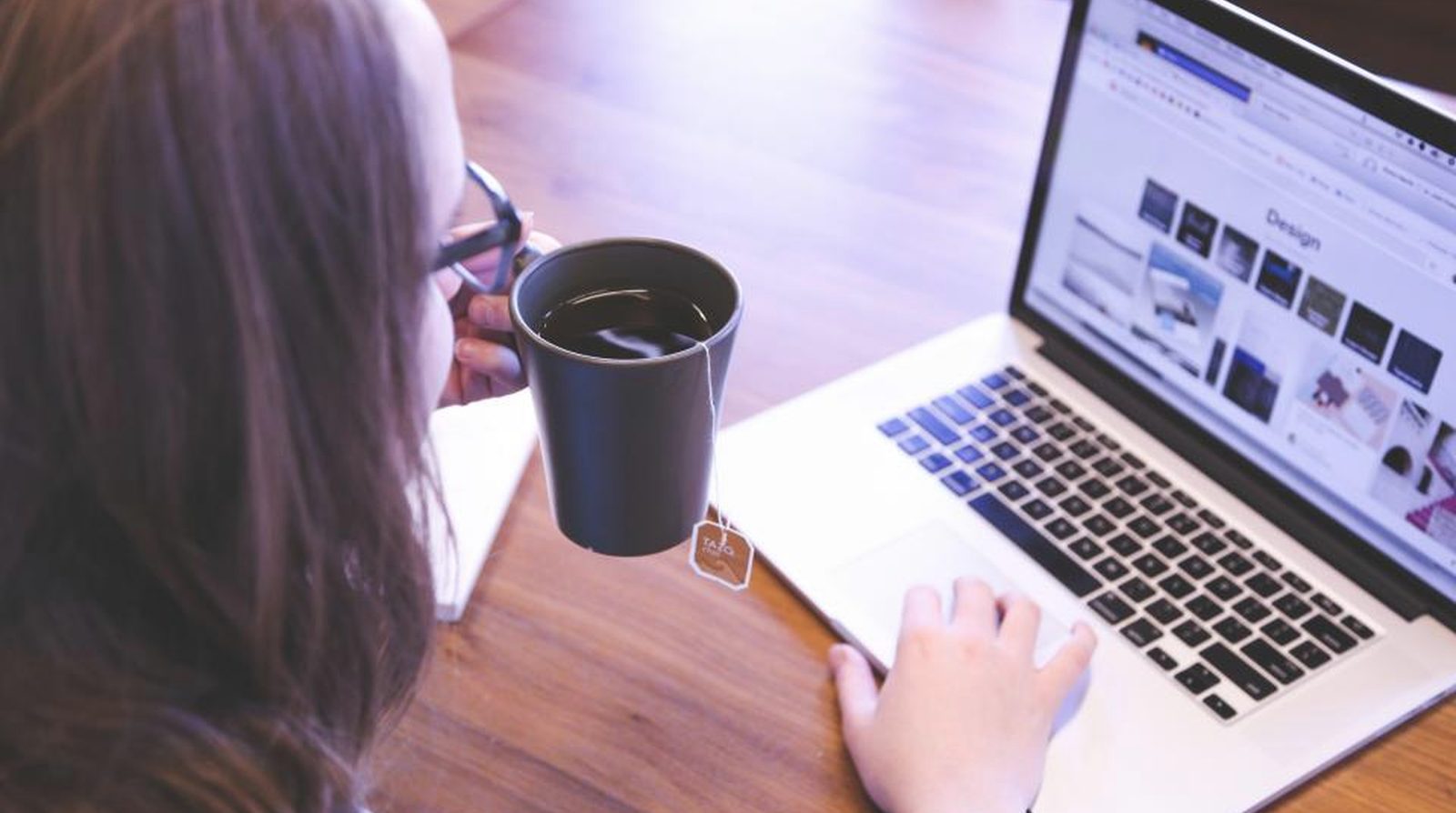 Chủ shop ngồi bên laptop cùng ly cà phê xem báo cáo hiệu suất website trên Google Search Console
