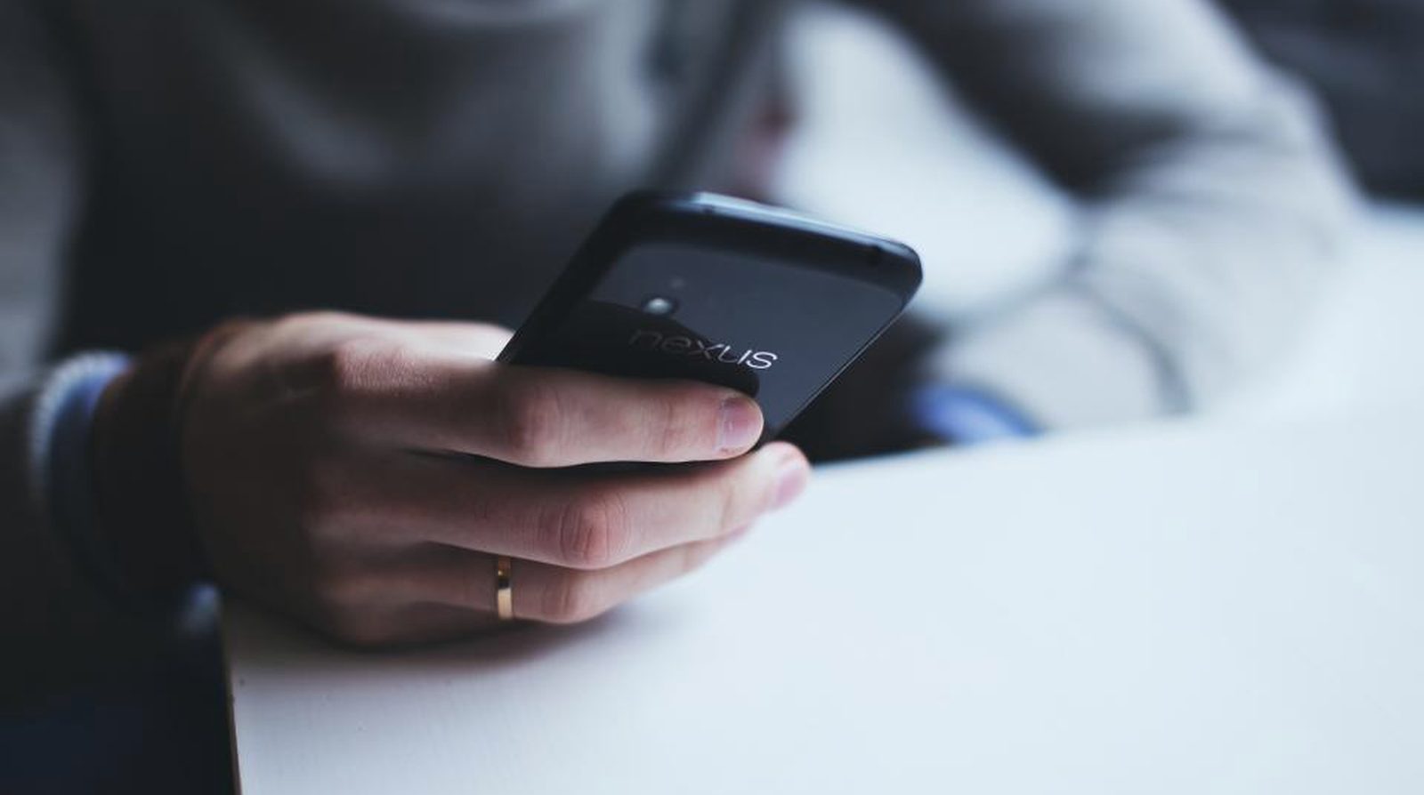 A person holding a phone viewing a running ad, each click needing a UTM tag to reveal its origin