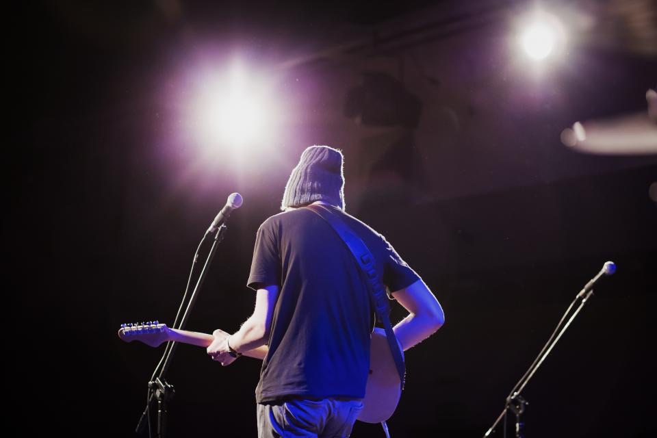 Nghệ sĩ guitar trên sân khấu dưới ánh đèn - soundcheck và tổng duyệt quyết định chất lượng đêm diễn